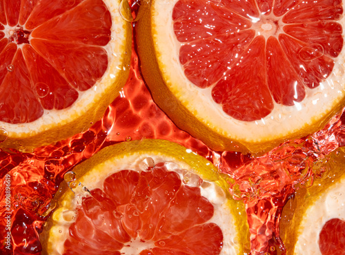 Top view of fresh grapefruit slices submerged in clear rippling water