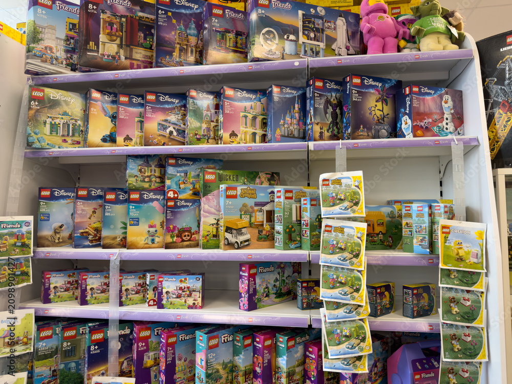Obraz premium Toy store shelf filled with colorful lego disney and friends building set boxes on display in a retail aisle