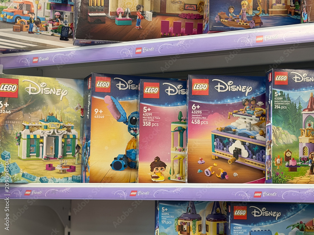 Fototapeta premium Toy store shelf filled with lego disney building set boxes on display