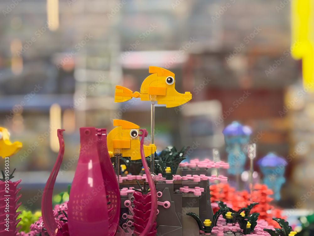 Fototapeta premium Colorful lego fish and coral display in a playful underwater scene with blurred background, creative toy art and bright decorative details.
