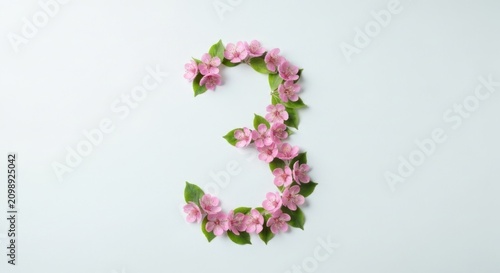 Number three formed by small pink flowers and leaves on a white background