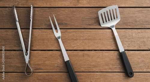 Metal BBQ tools on wooden planks