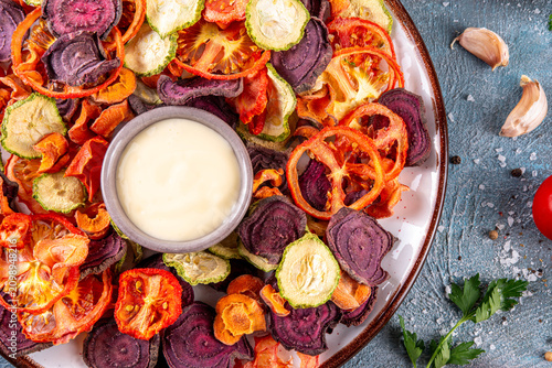 Healthy alternative for traditional potato chips, snack air fried vegetables chips, raw organic dehydrated veggie chips, beets, carrots, zucchini, kale, tomatoes, with white sauce dip