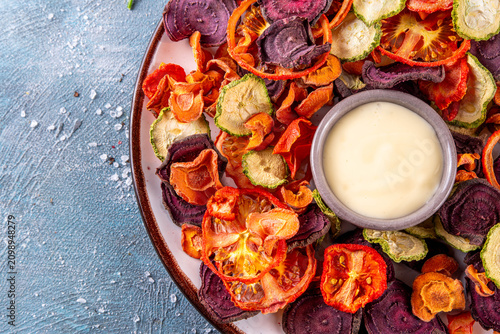 Healthy alternative for traditional potato chips, snack air fried vegetables chips, raw organic dehydrated veggie chips, beets, carrots, zucchini, kale, tomatoes, with white sauce dip