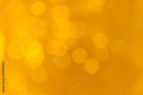 Abstract warm golden bokeh lights background with soft yellow glow