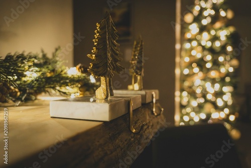 Cozy Christmas interior with mantle decorations and blurred sparkling tree background
