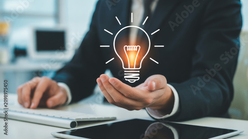 A professional business person holding a glowing digital light bulb concept for innovative solutions