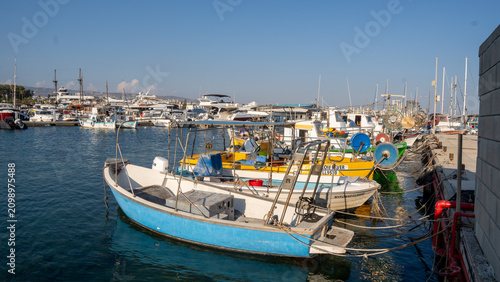 Blue fishing boat rests in calm harbor waters