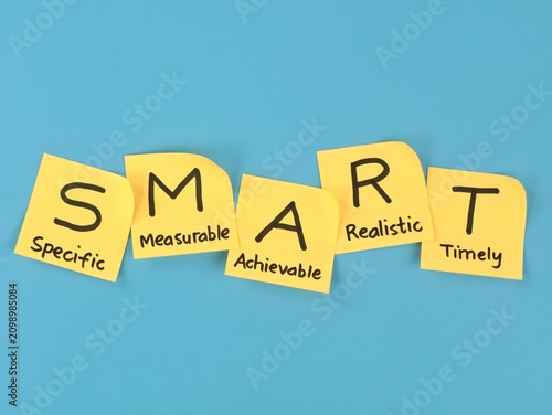 SMART (Specific, Measurable, Achievable, Realistic, and Timely) handwritten on yellow adhesive notes. Perfect for business strategy, personal development, project management, and motivational content