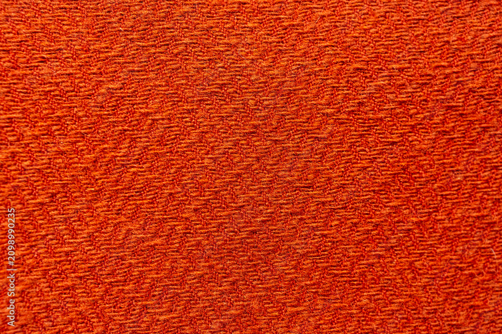 Naklejka premium Orange knitted textile texture with abstract pattern
