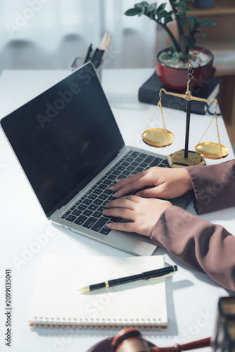 Legal Consultation: A close-up view capturing the atmosphere of legal consultation. A laptop, scales, and documents are arranged on the table, creating a professional environment