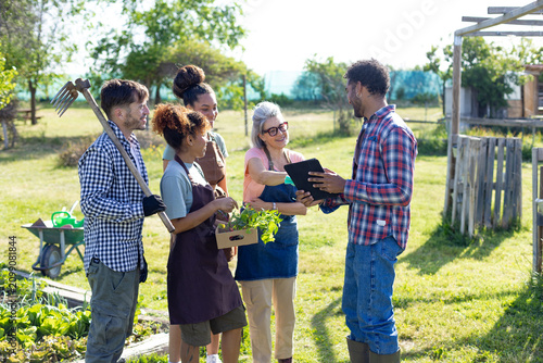 Diverse people discussing farming plans using digital tablet