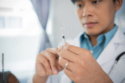 Quadro su tela A male healthcare worker wearing gloves safely administers a vaccine to promote disease prevention, well-being, research, and attentive patient care in a clinical setting