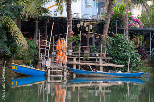 Rustic Riverside Dock with Traditional Blue Boats and Life Buoys