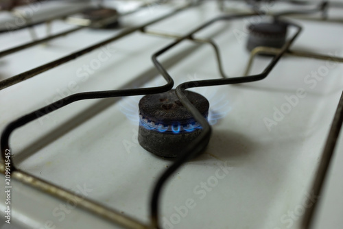 Фотография Gas stove with blue flame, the concept of energy crisis and lack of heating and
