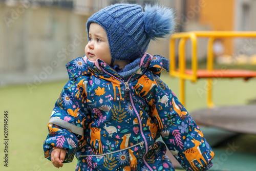 Toddler Wearing Warm Winter Clothing at Playground in Autumn