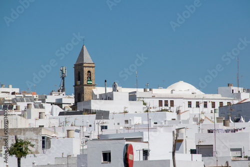 White village skyline and church tower in Conil de la Frontera, Spain