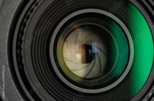 Close-up of Camera Lens Aperture with Green Reflection,Macro,A detailed macro shot capturing the intricate iris diaphragm blades of a camera lens with a prominent green light reflection on the glass s