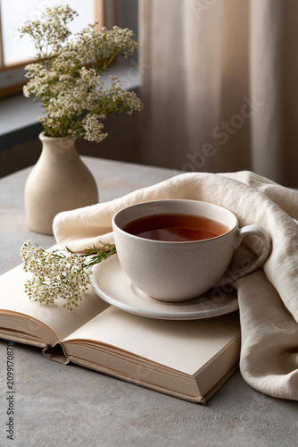 Quiet luxury home scene with herbal tea book and soft linen highlighting affordable longevity slow living and calm wellness lifestyle