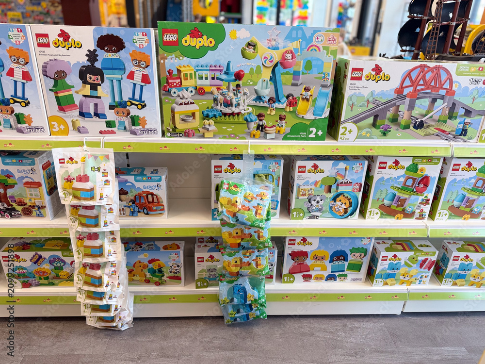 Fototapeta premium Colorful toy store shelf filled with lego duplo boxes and hanging packs for young children