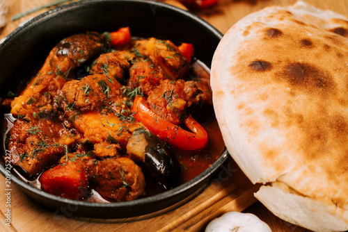 Fotografie Hearty bowl of Ajapsandali vegetable stew served with warm flatbread in a rustic