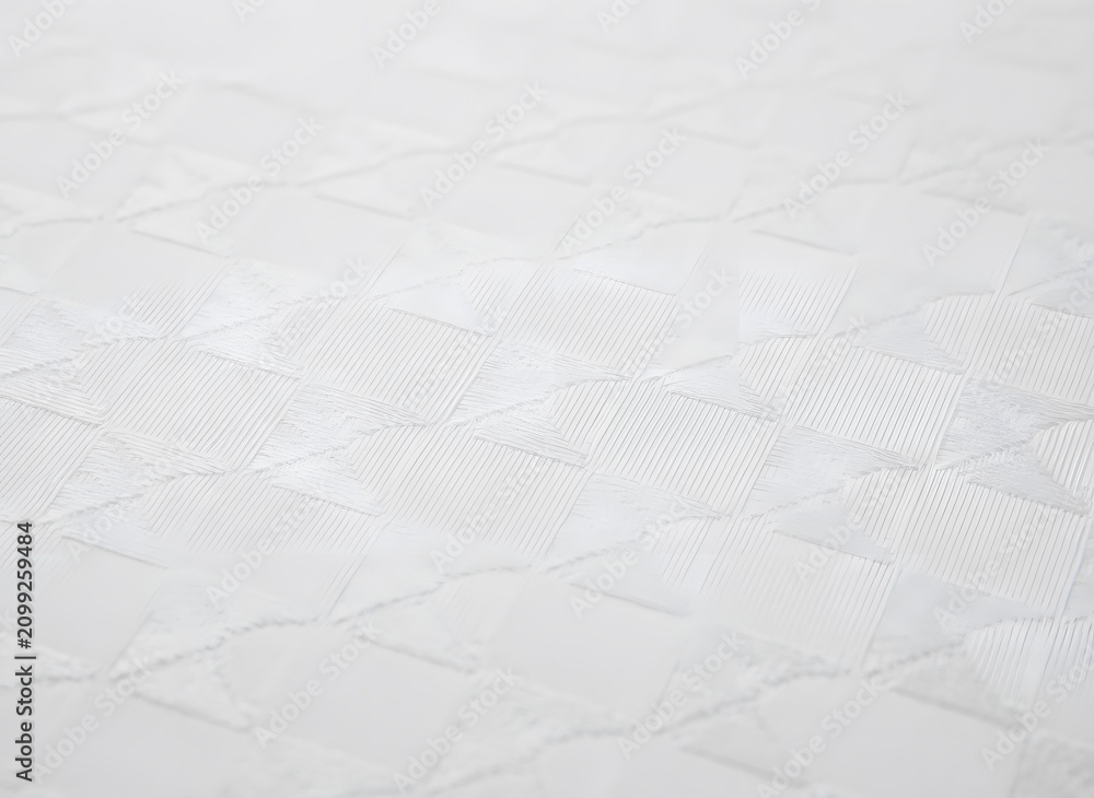 Obraz premium Close-up of pristine white quilted fabric surface, showcasing soft textile texture and intricate stitching pattern for comfort and bedding aesthetics