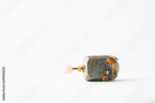 Old small electric motor isolated on a light background
