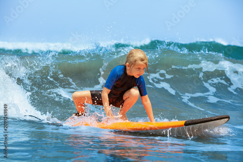 Canvas Print Happy young surfer girl with surfboard have fun on beach, riding on small ocean waves