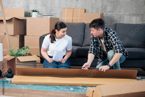 Foto Young couple assembling furniture in new home together