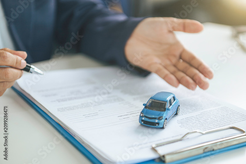 Obraz na plátně Car insurance consultation with vehicle model and policy documents evaluating co