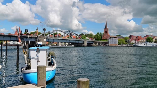 Video showing a fishing boat gently rocking in the wind in front of King Christian X Bridge, Saint Mary Church and the old town of Sonderborg.