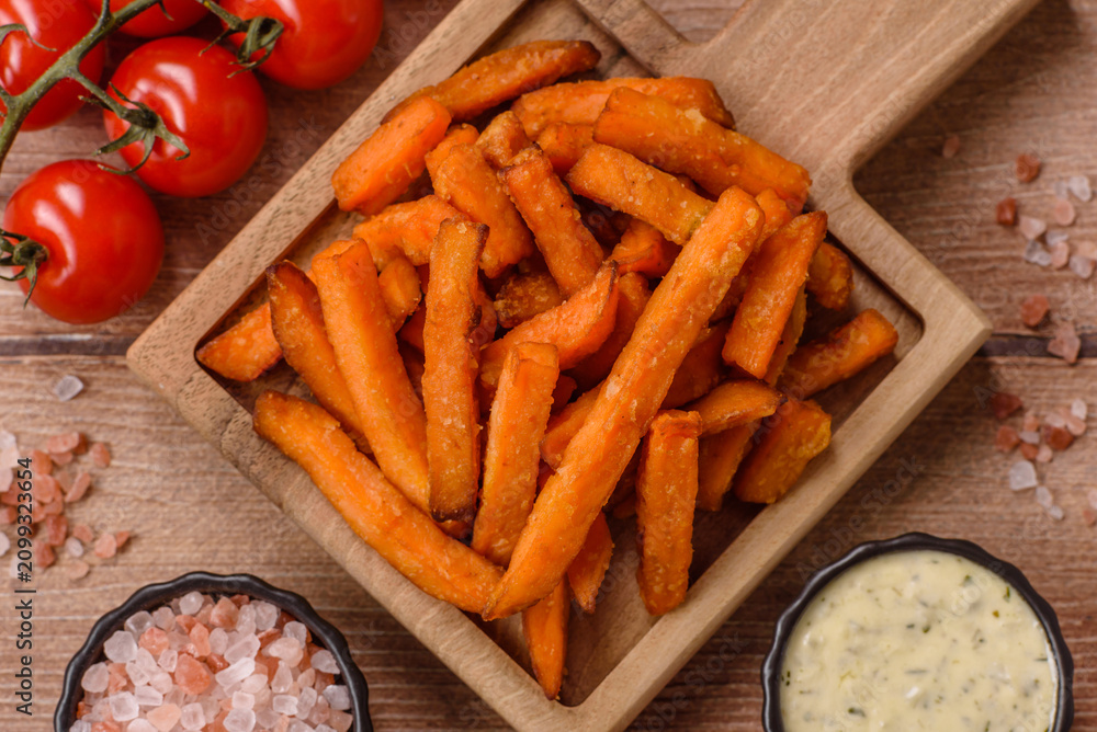 Obraz premium Seasoned sweet potato fries with sauce, fast food. Sweet potato fries