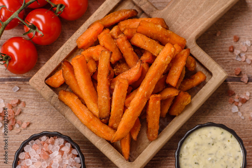 Seasoned sweet potato fries with sauce, fast food. Sweet potato fries