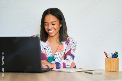 Fotografía Smiling businesswoman working on laptop at home office