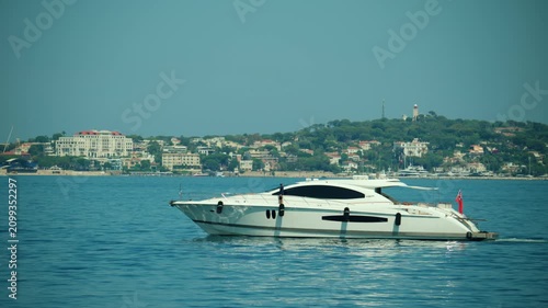 Modern luxury yacht cruising in the blue waters of the mediterranean sea near the coastline of cap d'antibes, embodying wealth and freedom, Golfe Juan, France