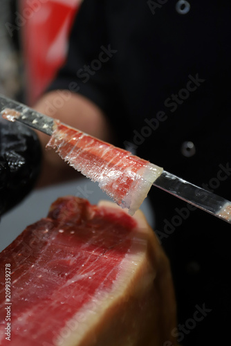 chef experto en corte de jamón cortando una loncha de jamón ibérico