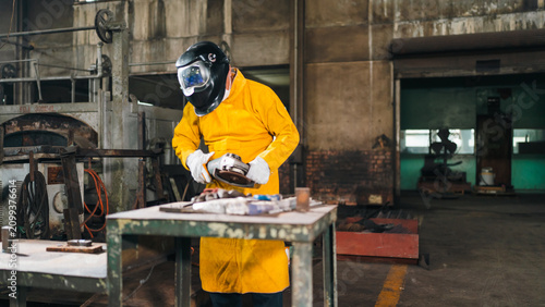 Foto Welder worker helmet yellow apron glove metal workshop tool industrial scene wit