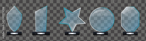 Foto Five different glass award trophies with silver labels on dark bases for various honors