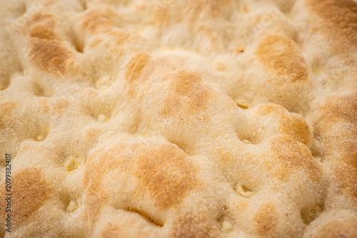 Pizza crust texture close-up of freshly baked dough, crispy golden brown surface of traditional Italian pizza base