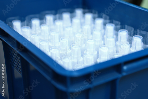 Large number of vials are in drawer. Production of cosmetics for skin care. Finished skin care products. Bottle has no label