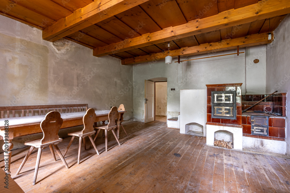 Obraz premium Traditional rustic room with wooden furniture and tiled stove
