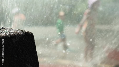 girl jumps in sprinklers on hot Brooklyn  summer day