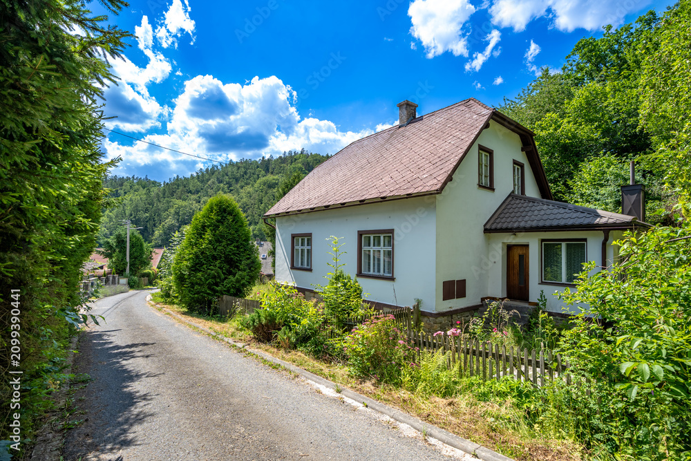 Obraz premium Rural house with brown roof beside winding road