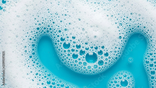 Abstract white soap foam curves and blue bubbles pattern on liquid cleaning cosmetic background