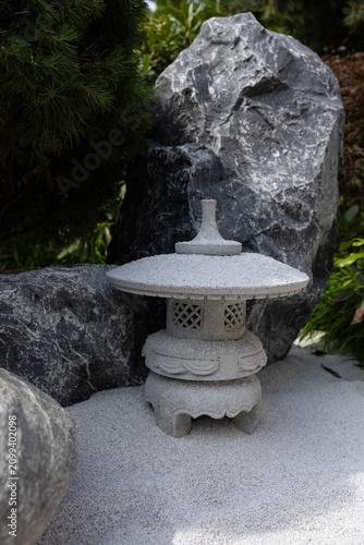 Canvas Print Stone pagoda lantern in japanese zen rock garden with white sand and boulders