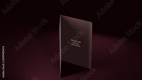Rotating greeting card on camera shift, opening on maroon table, revealing gold hearts and message