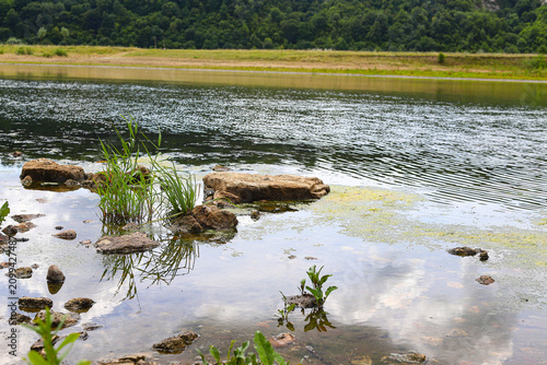 Picturesque stone rapids on the shallow water of a clean river. Picturesque landscape, wild nature in summer. Dniester in Ukraine.