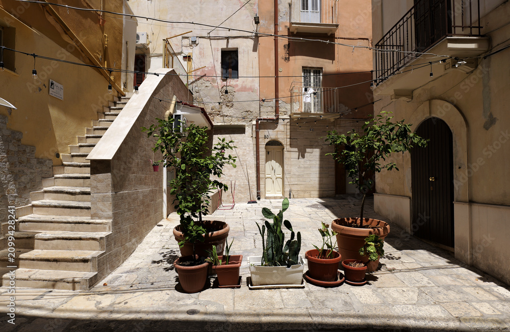 Obraz premium Monopoli old town courtyard with potted plants