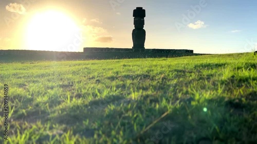  Ahu Tahai ceremonial complex on Easter Island, Chile. Historic Moai statues overlooking the Pacific Ocean on the sunset with scattered clouds.