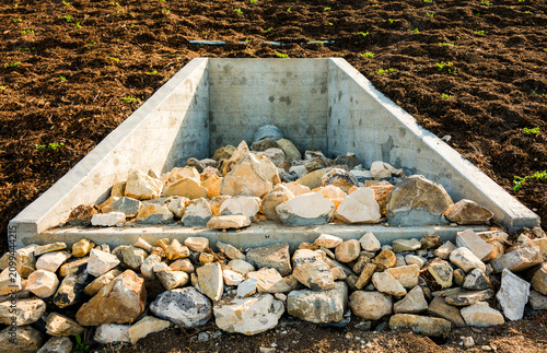 Concrete drainage system with stones in a landscaped area for effective water management